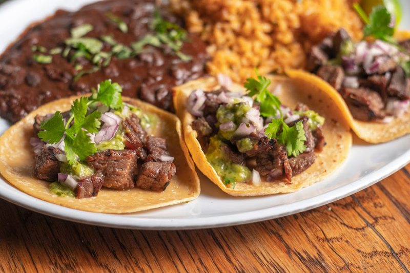 a plate with steak tacos on the table